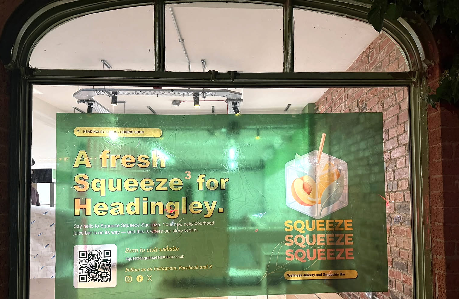 The Squeeze Squeeze Squeeze banner in the shop window in Headingley, reading “A fresh Squeeze³ for Headingley.”